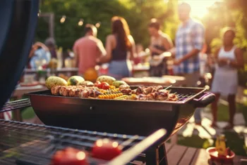Family gathering using charcoal grill for backyard BBQ party