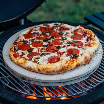 pepperoni pizza baking on ceramic barbecue smoker grill